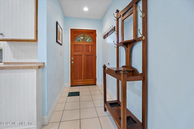 foyer featuring light tile patterned flooring and baseboards