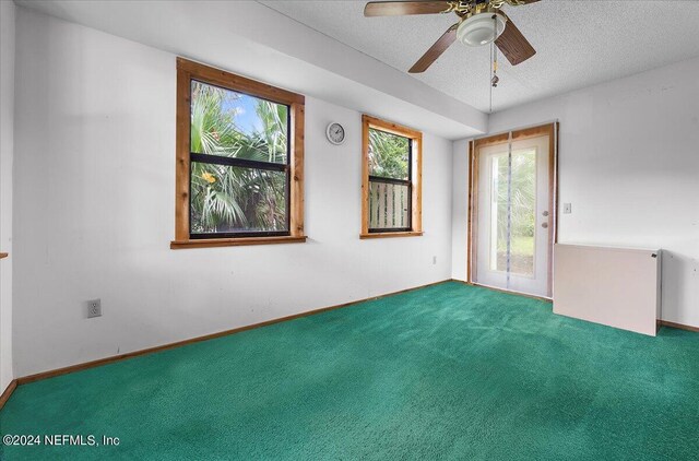 carpeted empty room with a textured ceiling and ceiling fan