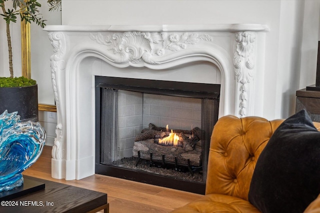 details featuring a tiled fireplace and hardwood / wood-style flooring