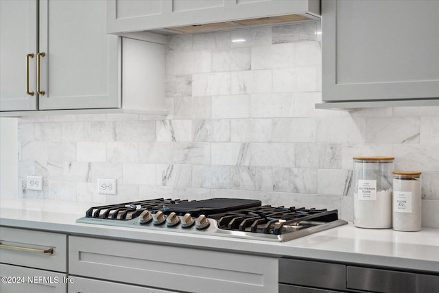 kitchen with stainless steel gas cooktop, exhaust hood, and gray cabinets