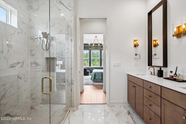 bathroom featuring a shower with door, vanity, and a notable chandelier