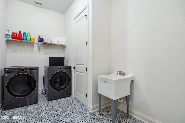 laundry room featuring independent washer and dryer and a textured ceiling