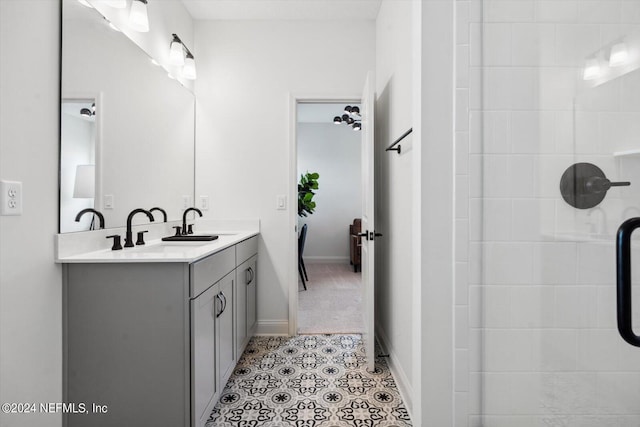 bathroom with tile patterned floors, tiled shower, and vanity