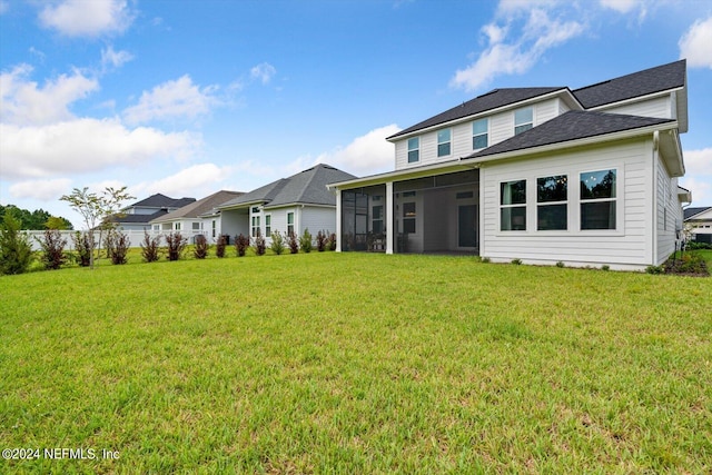 back of house with a sunroom and a yard