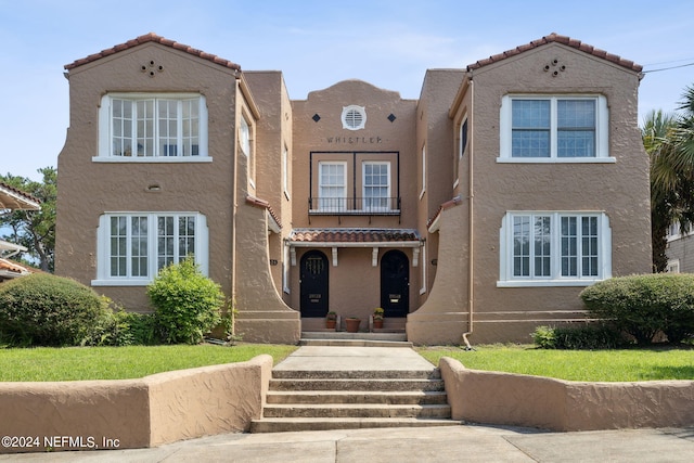 mediterranean / spanish-style home with a front yard