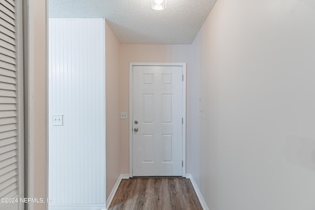 corridor featuring a textured ceiling and wood-type flooring