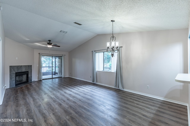 unfurnished living room featuring a fireplace, ceiling fan with notable chandelier, plenty of natural light, and dark hardwood / wood-style flooring