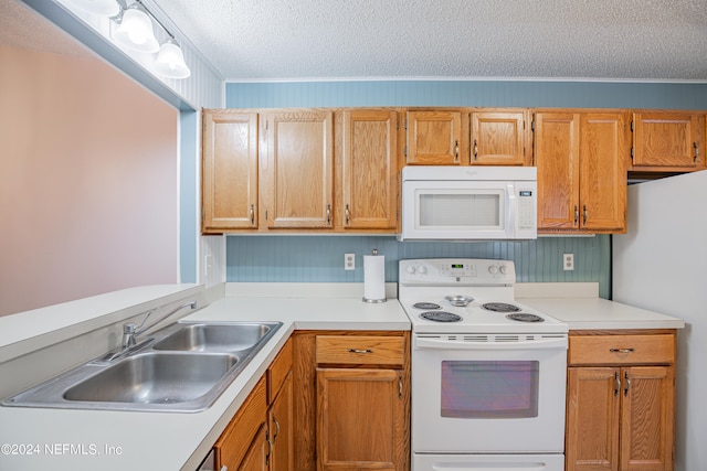 kitchen featuring white appliances, crown molding, a textured ceiling, and sink