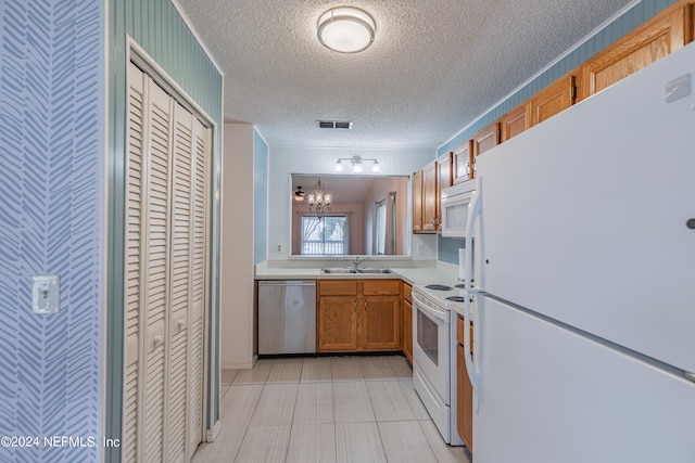 kitchen featuring white appliances, a textured ceiling, light tile patterned floors, an inviting chandelier, and sink