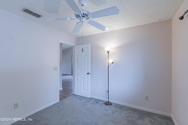 unfurnished bedroom featuring ceiling fan, carpet, and a textured ceiling