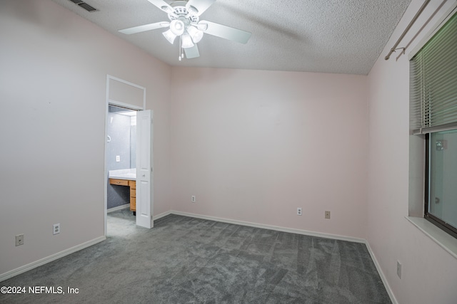 unfurnished bedroom featuring a textured ceiling, ceiling fan, dark colored carpet, and lofted ceiling