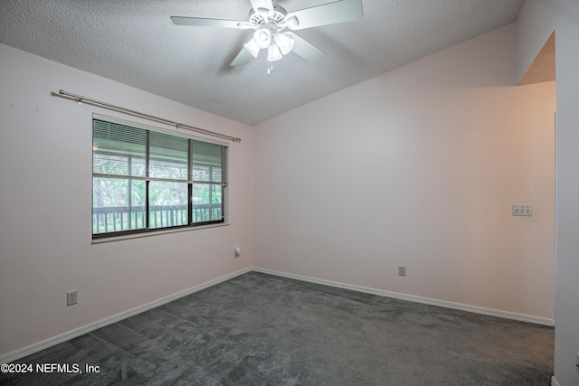 carpeted spare room featuring ceiling fan, vaulted ceiling, and a textured ceiling