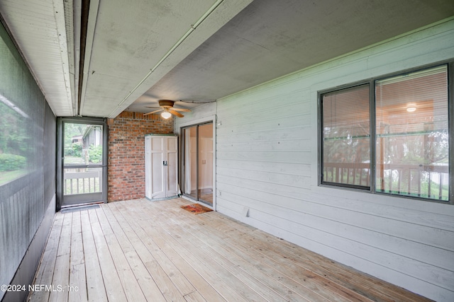 unfurnished sunroom featuring ceiling fan