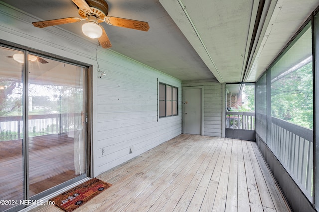 unfurnished sunroom with ceiling fan