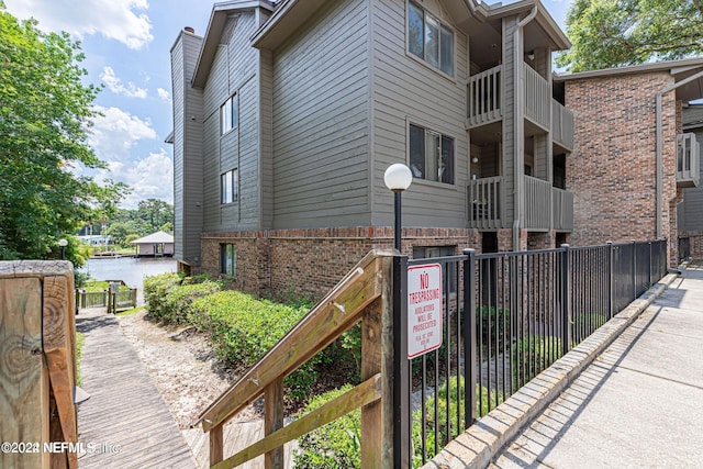 view of side of home featuring a balcony and a water view