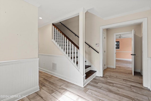 staircase featuring crown molding, hardwood / wood-style floors, and ceiling fan