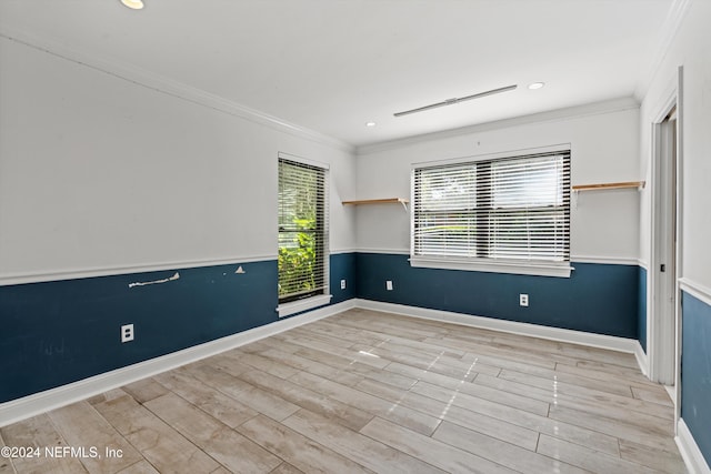 spare room featuring light hardwood / wood-style floors and crown molding