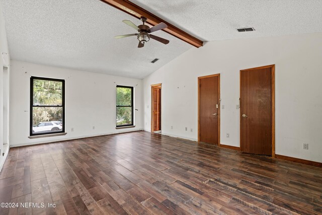 spare room featuring lofted ceiling with beams, ceiling fan, dark wood-type flooring, and a textured ceiling