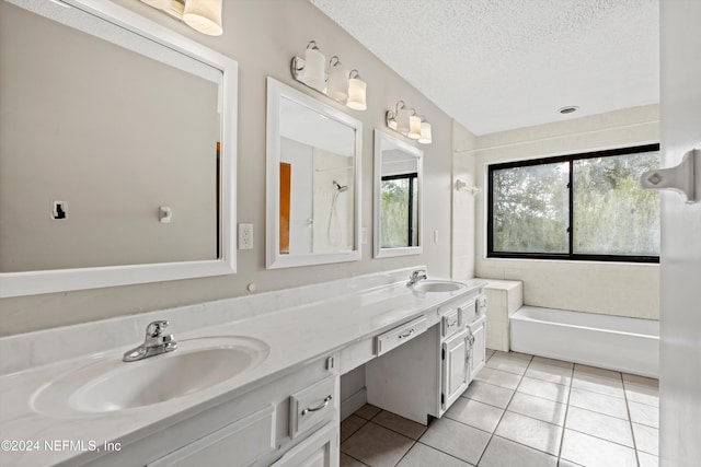 bathroom featuring tile patterned floors, vanity, a healthy amount of sunlight, and a textured ceiling