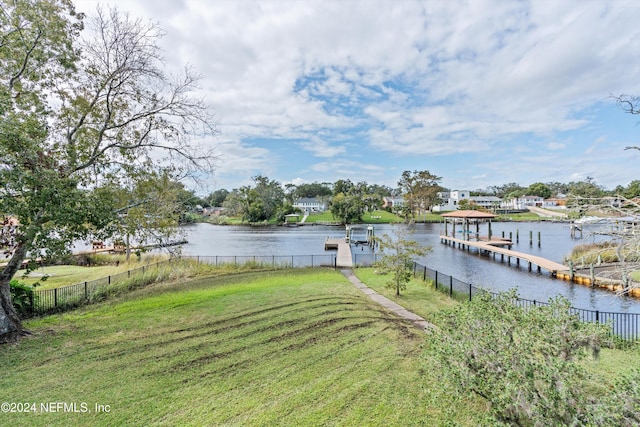 dock area with a lawn and a water view