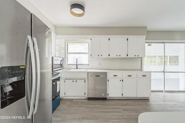 kitchen featuring sink, white cabinetry, stainless steel appliances, and light hardwood / wood-style floors