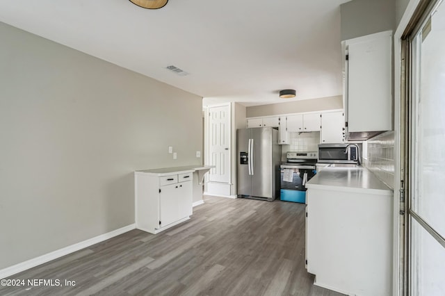 kitchen featuring tasteful backsplash, appliances with stainless steel finishes, sink, white cabinetry, and dark hardwood / wood-style floors