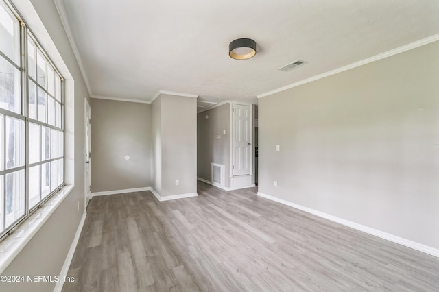 empty room featuring ornamental molding and light hardwood / wood-style floors