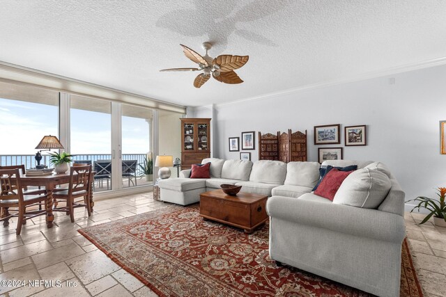 living room featuring ceiling fan, crown molding, and a textured ceiling