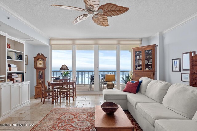 living room with expansive windows, a textured ceiling, ceiling fan, crown molding, and a water view