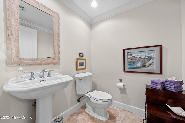 bathroom with tile patterned flooring, toilet, and ornamental molding