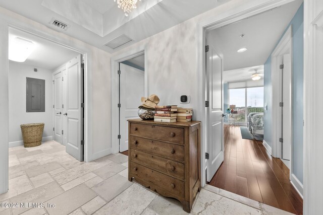 corridor featuring electric panel and light hardwood / wood-style floors