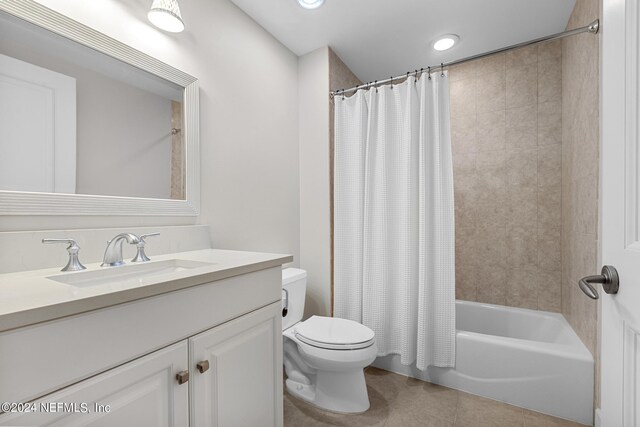 full bathroom with vanity, tile patterned flooring, shower / bathtub combination with curtain, and toilet