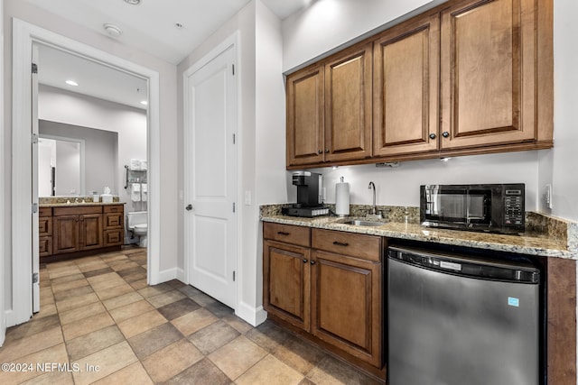 kitchen with dishwasher, light stone countertops, and sink