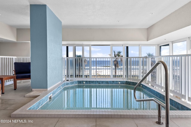 view of swimming pool with a water view and a jacuzzi