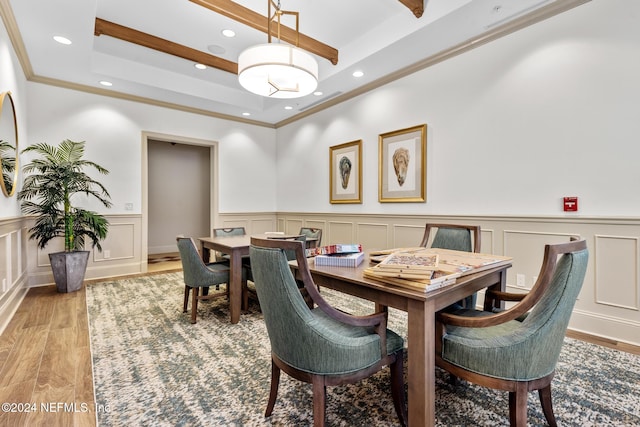 dining area featuring a raised ceiling, crown molding, and light hardwood / wood-style flooring