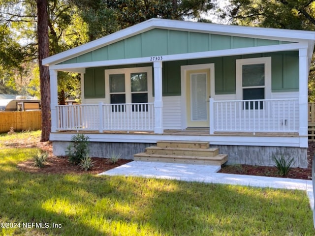 view of front of house with covered porch and a front yard