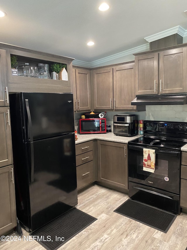 kitchen with light wood-type flooring, black appliances, crown molding, and decorative backsplash