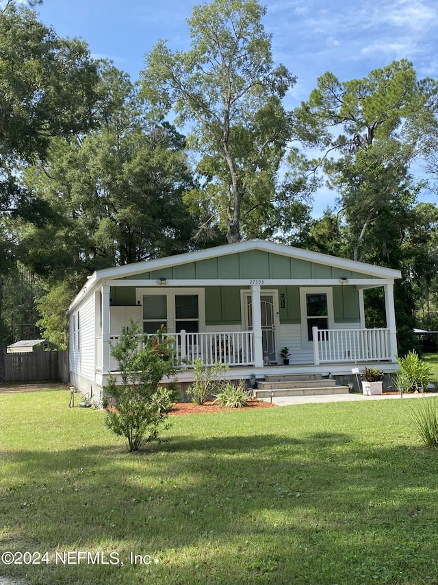 manufactured / mobile home featuring a front lawn and covered porch