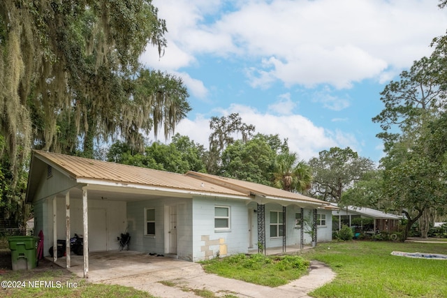 back of property featuring a carport and a yard