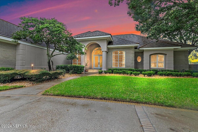 mediterranean / spanish-style house with a lawn