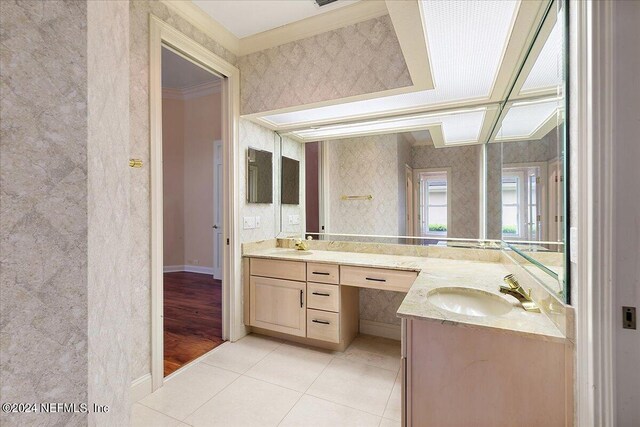 bathroom with tile patterned flooring, ornamental molding, and vanity