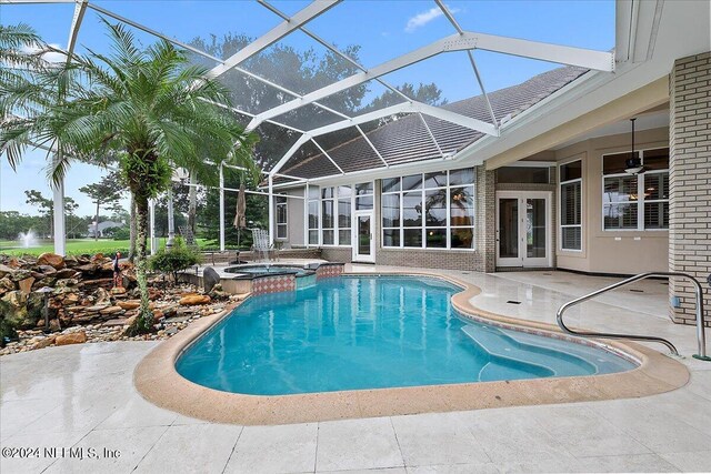 view of pool featuring a lanai, a patio area, french doors, and an in ground hot tub