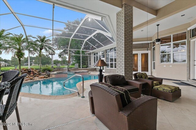 view of pool featuring an in ground hot tub, a patio area, glass enclosure, and french doors