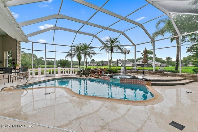 view of pool featuring a lanai, a patio area, and an in ground hot tub