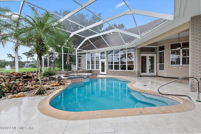 view of pool featuring a patio, an in ground hot tub, glass enclosure, ceiling fan, and french doors