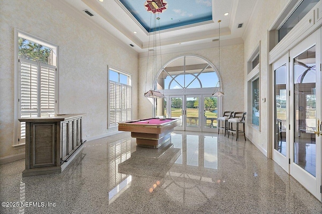 playroom with a towering ceiling, billiards, a raised ceiling, crown molding, and french doors