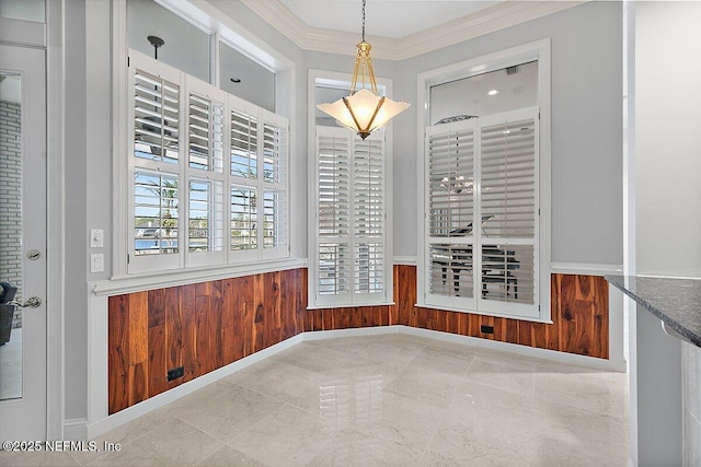 unfurnished dining area featuring crown molding and wood walls