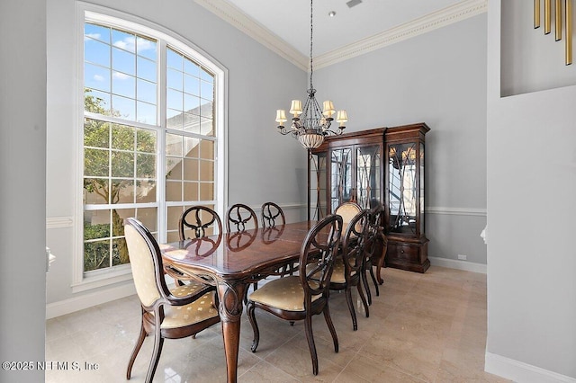 dining space featuring crown molding and a chandelier