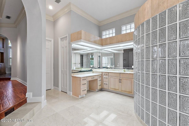 bathroom featuring crown molding, vanity, and a high ceiling