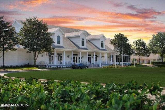 view of front of property featuring a porch and a lawn